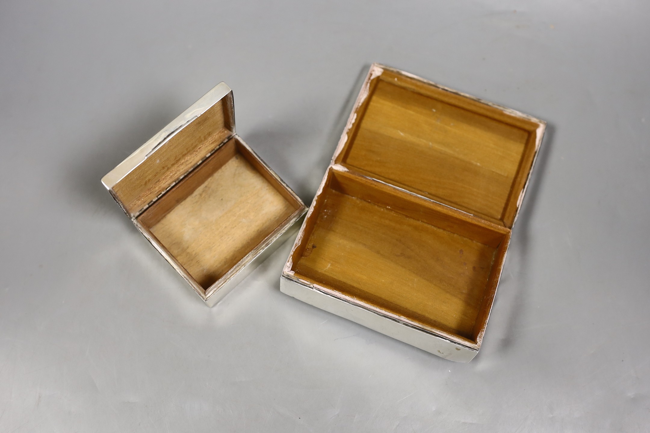 A George V silver mounted cigarette box, William Hutton & Sons, Birmingham, 1917, 89mm and a later larger Egyptian white metal cigarette box.